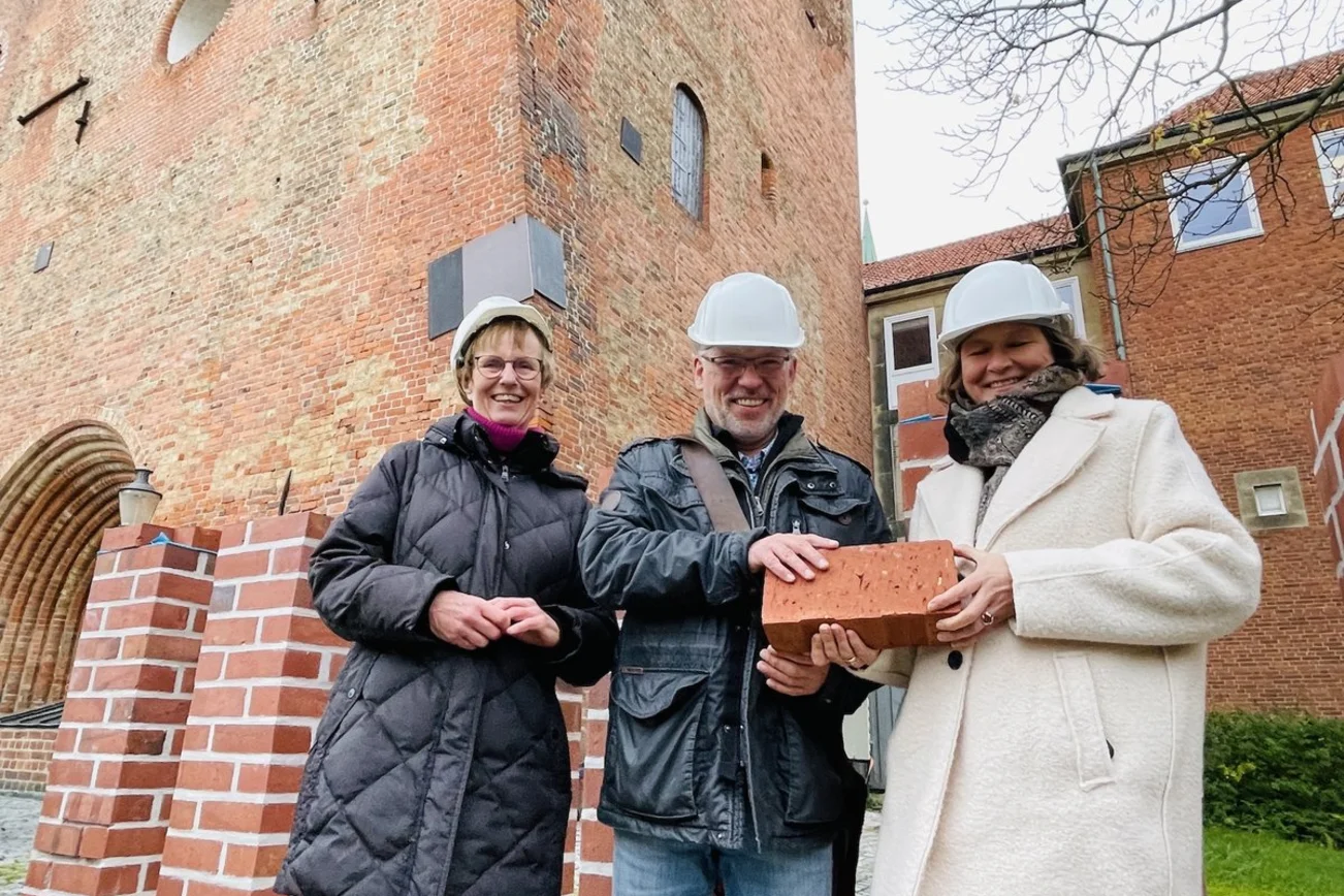Personen stehen vor einer Kirche