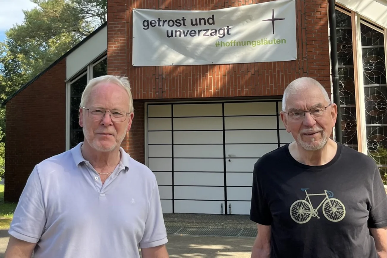 Zwei ältere Männer stehen vor der Augustinus-Kirche.