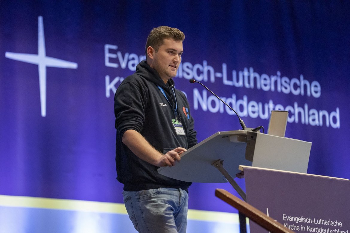 Ein Mann steht auf einer Bühne und spricht