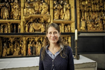Eine Frau steht lächelnd in einer Kirche - Copyright: Thorsten Wulff