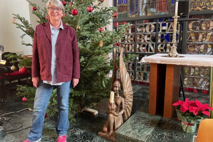 Eine Frau steht vor einem Christbaum in einer Kirche - Copyright: Eiben  