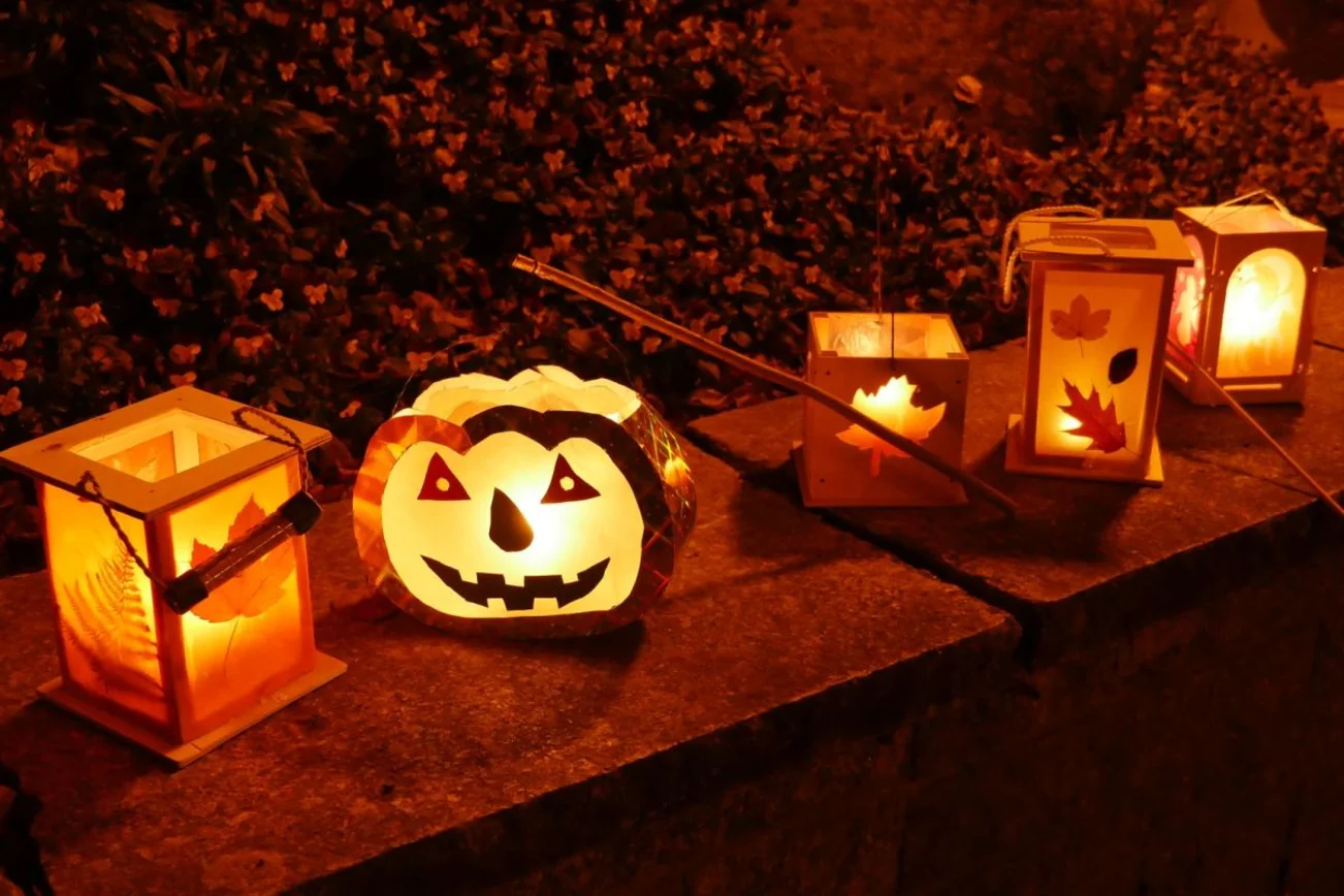 5 Kinderlaternen stehen auf einer Mauer.