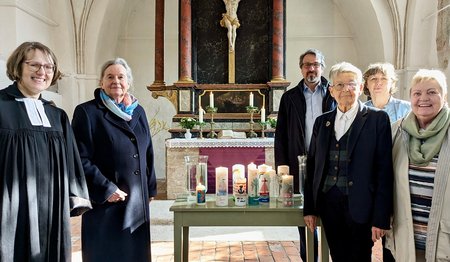 Gruppe von Menschen in einer Kirche, Kerzen auf Tisch, Altar 