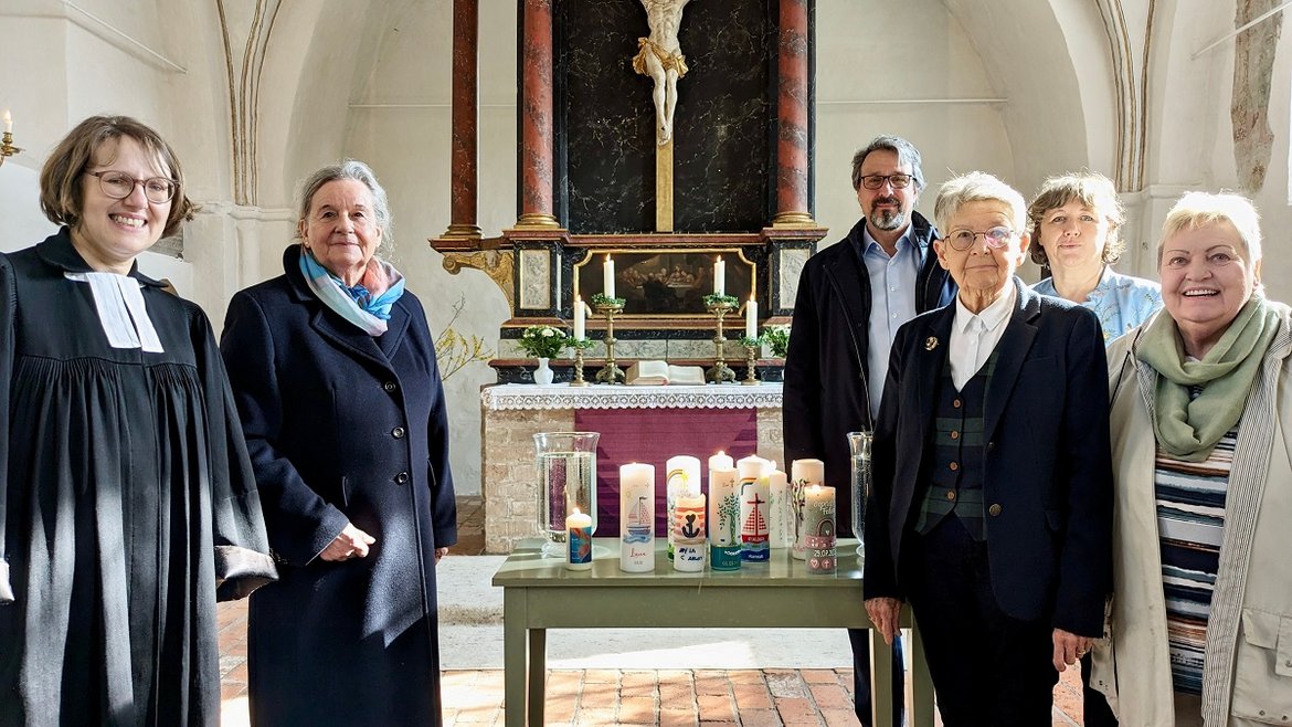Gruppe von Menschen in einer Kirche, Kerzen auf Tisch, Altar 