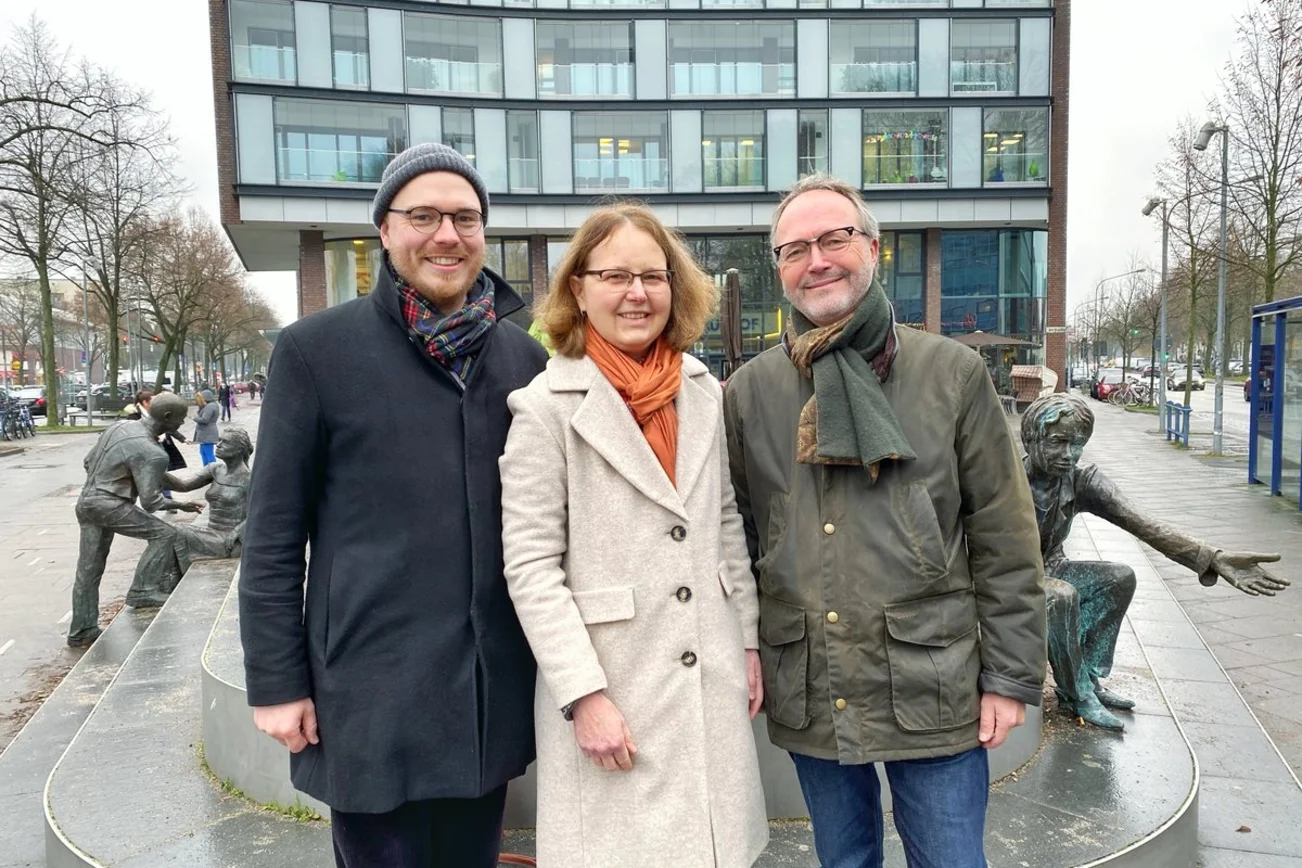 Drei Personen stehen lächelnd auf einem Platz im Lübecker Stadtteil Marli.