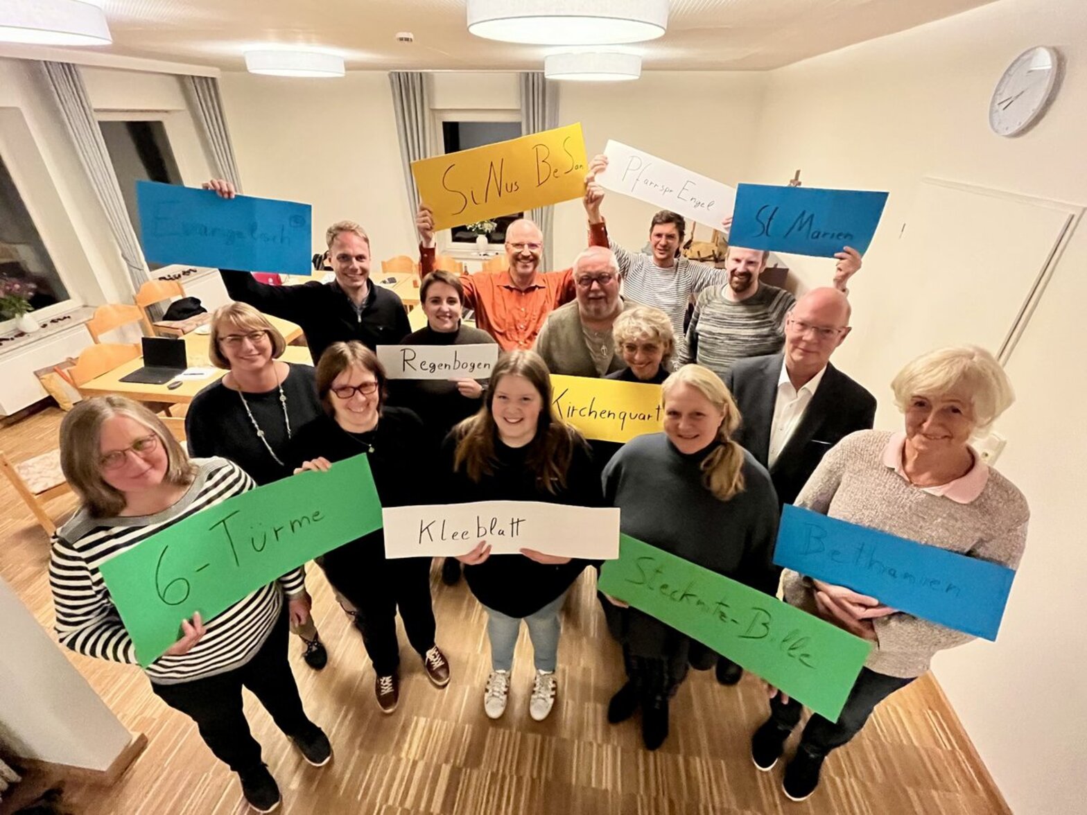 Menschen mit bunten Schildern in einem Raum