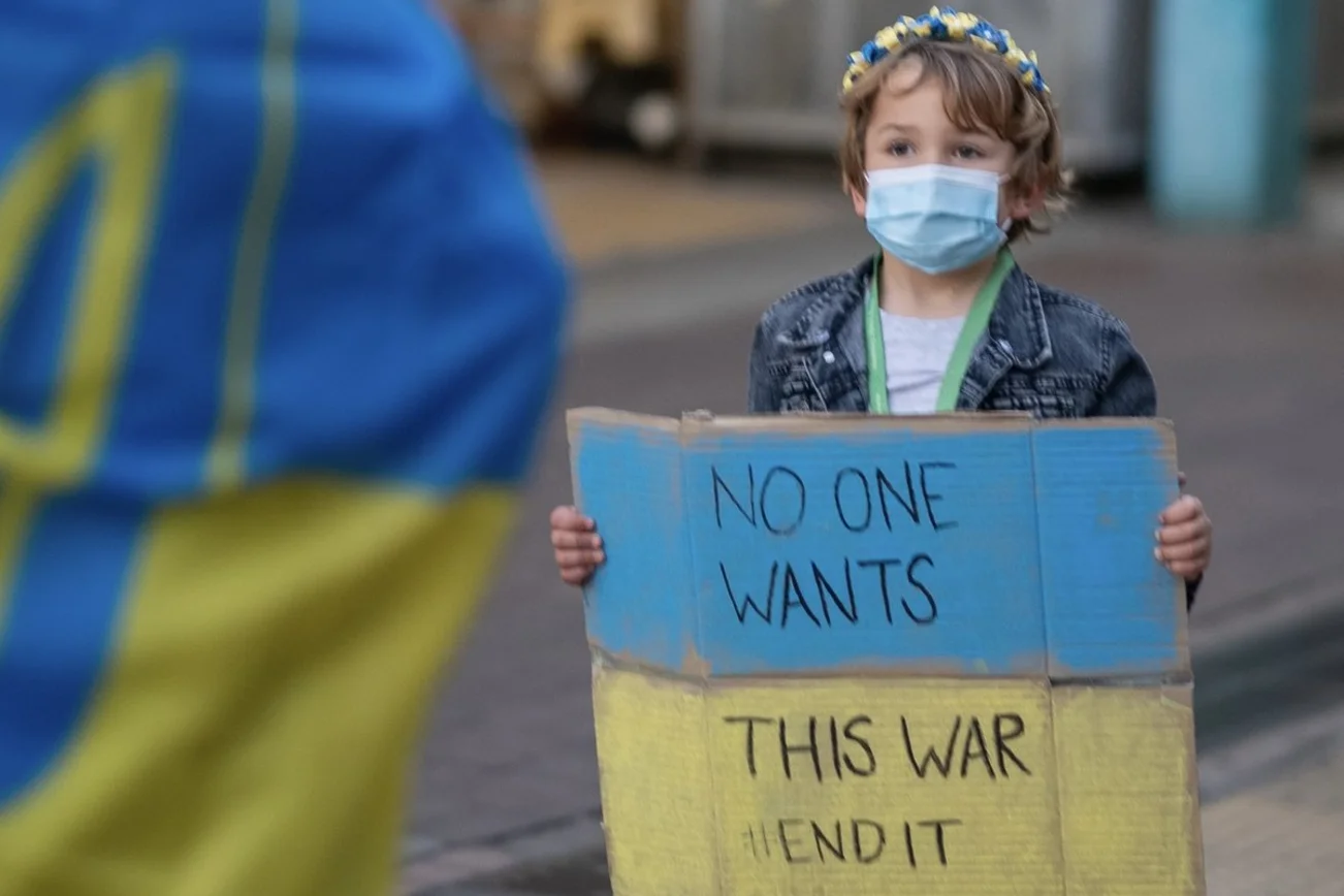 Ein kleines Kind hält ein Solidaritätsplakat für die Ukraine