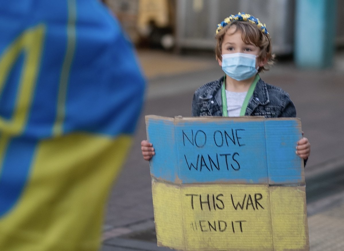 Ein kleines Kind hält ein Solidaritätsplakat für die Ukraine