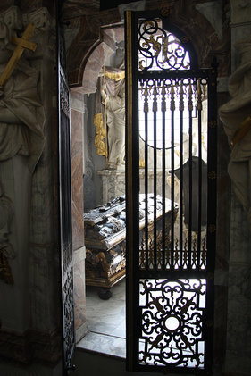 Blick durch eine Gittertür in eine Grabkapelle mit Sarkophag