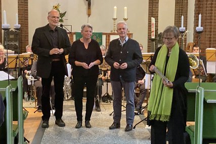 Drei Personen im Hintergrund in einer Kirche - davor eine Pastorin mit grüner Stola. - Copyright: Broder Feddersen