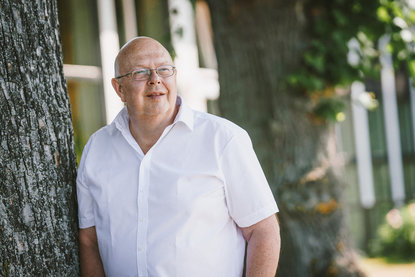 Ein Mann mit Brille lehnt an einen Baum und guckt in die Ferne. - Copyright: Guido Kollmeier