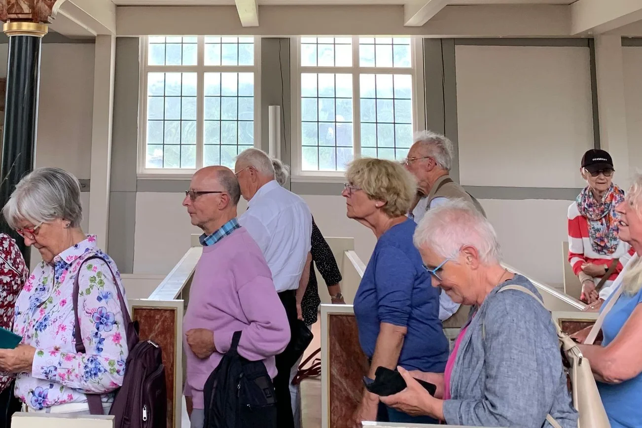 Die ehrenamtlichen Menschen stehen in der Nikolai-Kirche in Moorfleet..