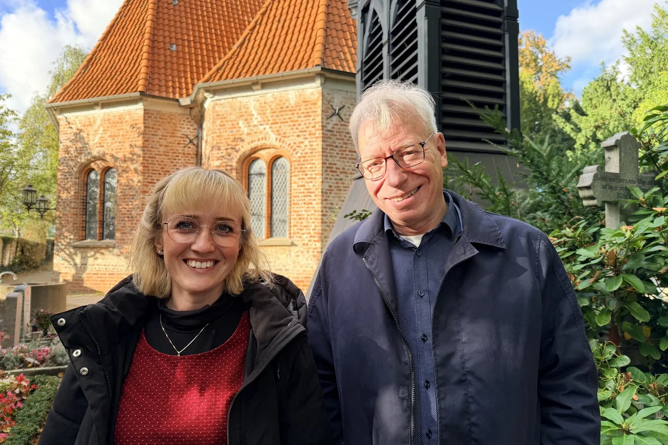 Zwei Menschen stehen vor einer Kirche 
