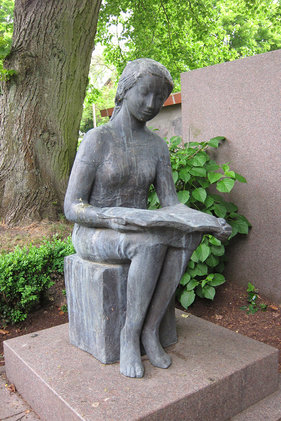 Die Skultptur einer lesenden Frauenfigur vor St. Lorenz Schmilau