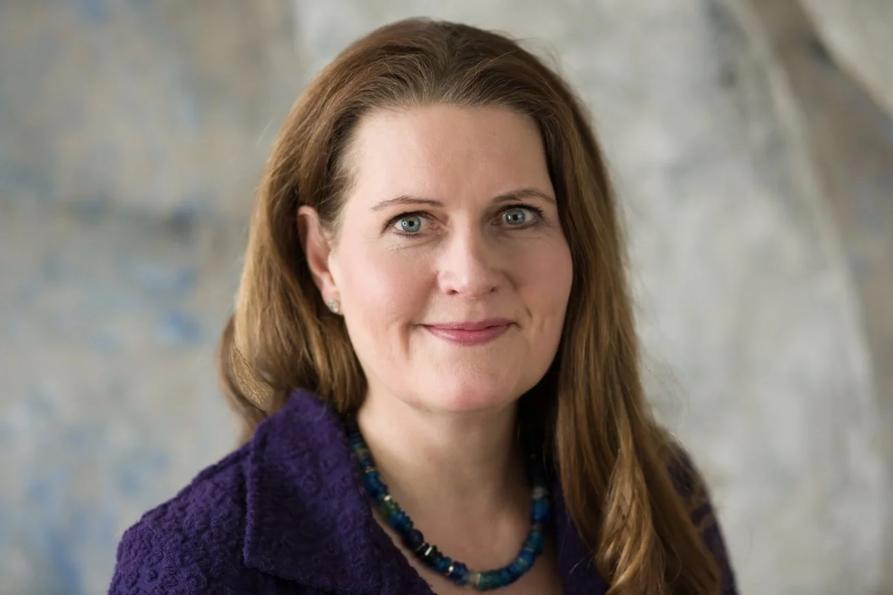 Eine Frau blickt in die Kamera. 