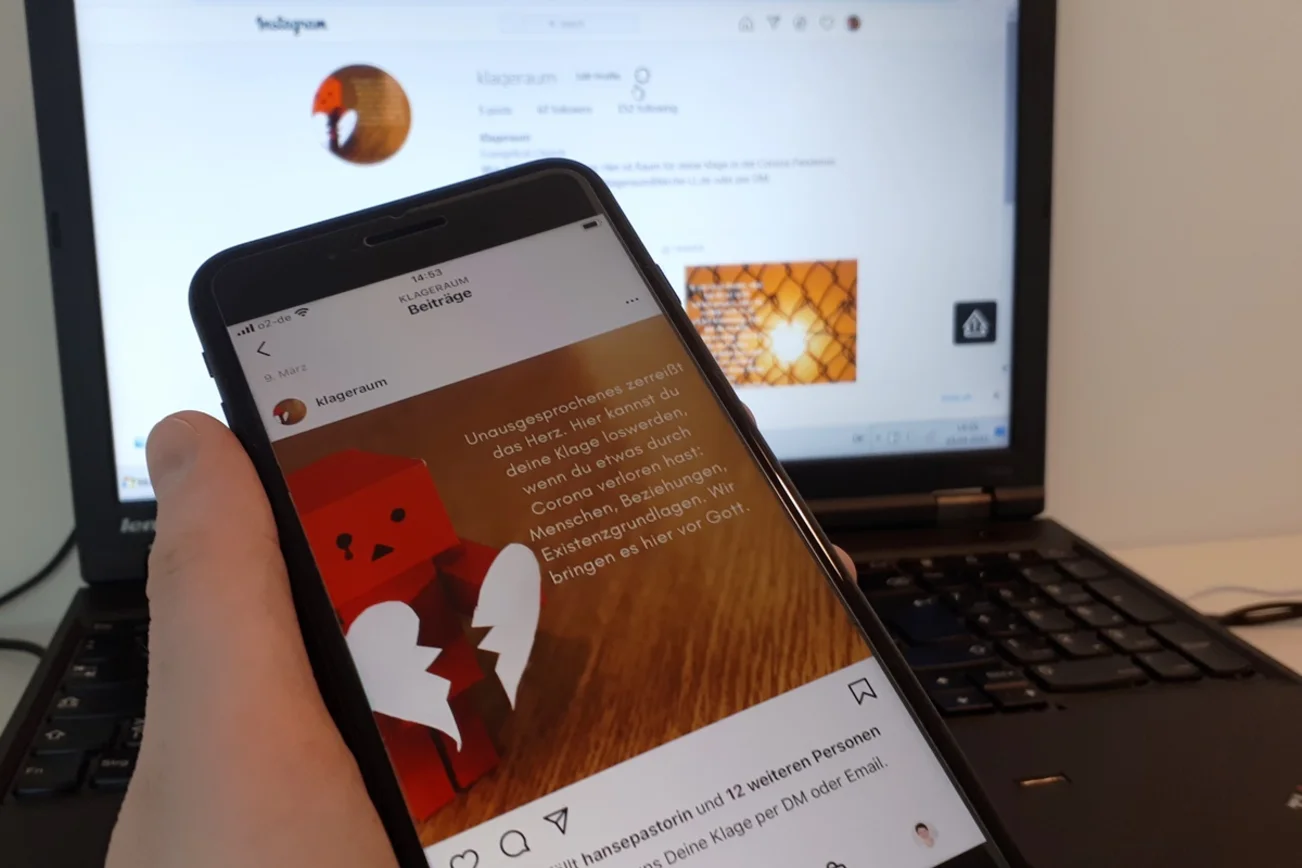 Ein Smartphone, im Hintergrund ein Laptop.