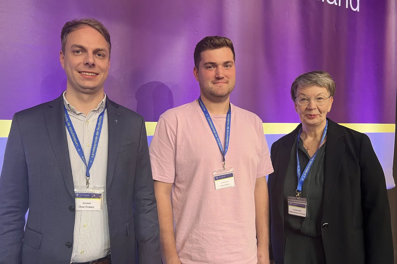 Drei Personen schauen in die Kamera