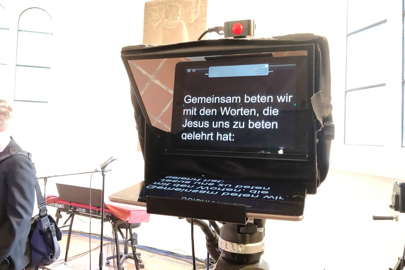 Ein Teleprompter mit dem Text "Gemeinsam beten wir mit den Worten, die Jesus uns zu beten gelehrt hat".