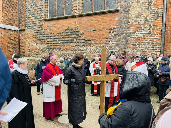 Menschen tragen ein Kreuz