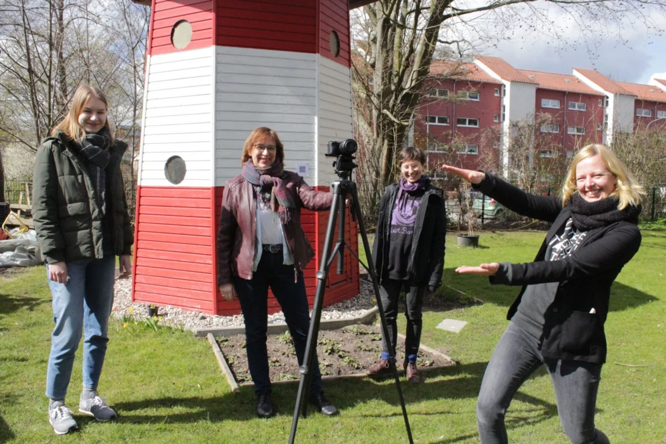 Die Macher hinter der Video-Reihe "Luther aus dem Häuschen" vor dem bekannten Leuchtturm der Luther-Melanchthon-Gemeinde in Lübeck.