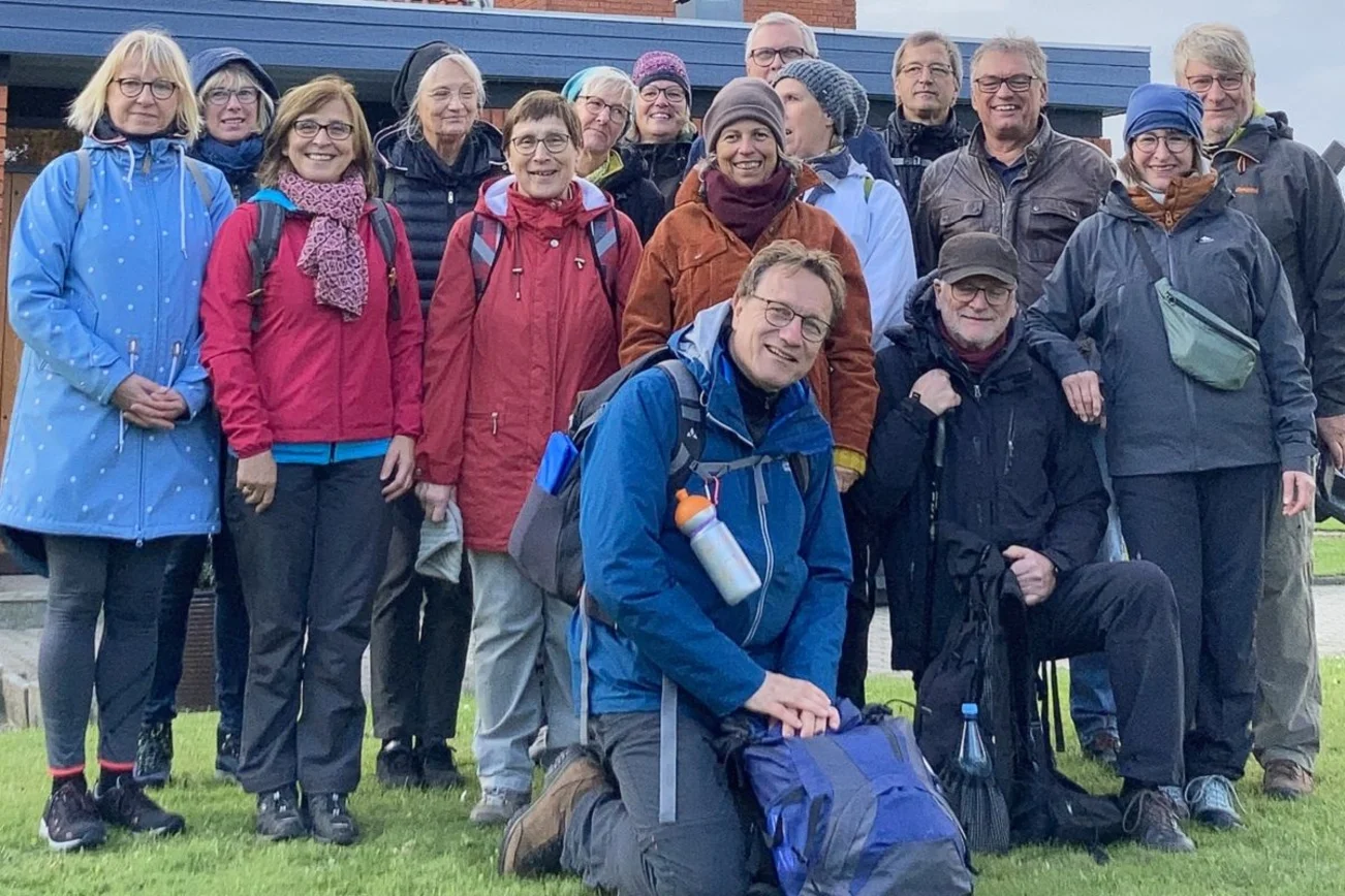 Eine Gruppe von Menschen in Wanderausrüstung lächelt in die Kamera.