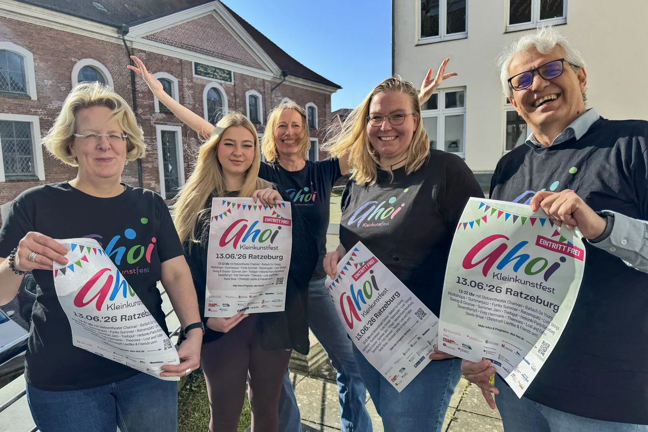 Menschen mit Plakaten schauen in die Kamera