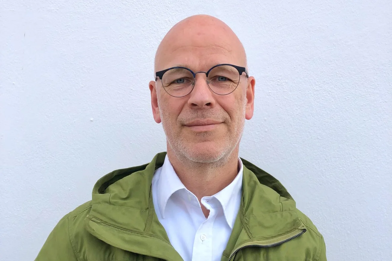 Ein Mann lächelt in die Kamera. 