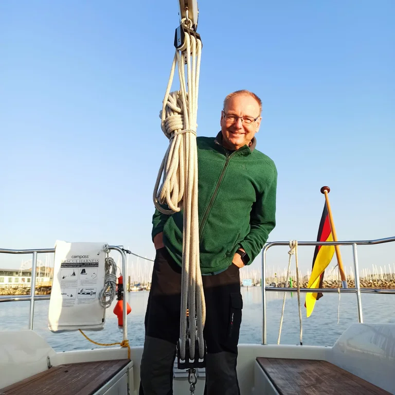 Mann steht auf einem Segelboot