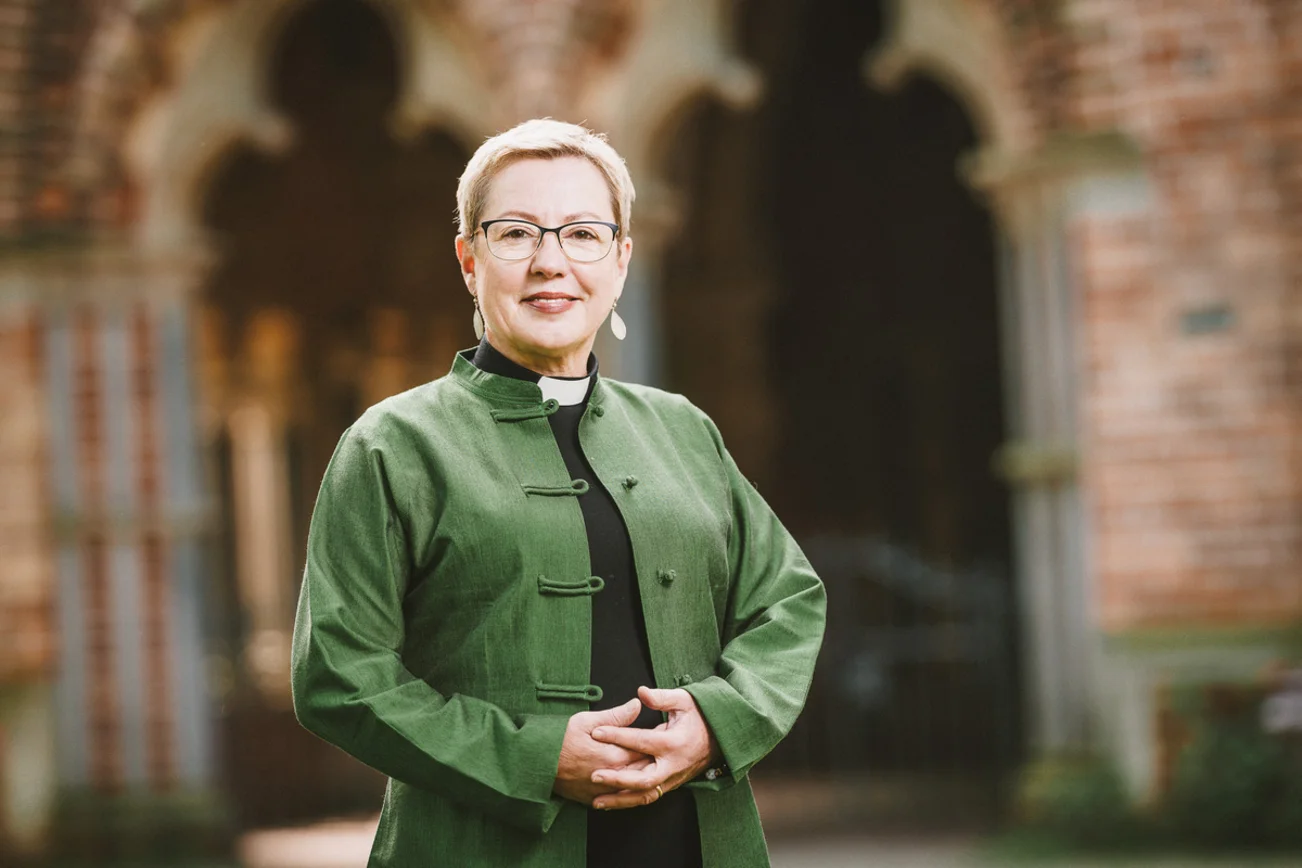 Frau guckt freundlich lächelnd in die Kamera.