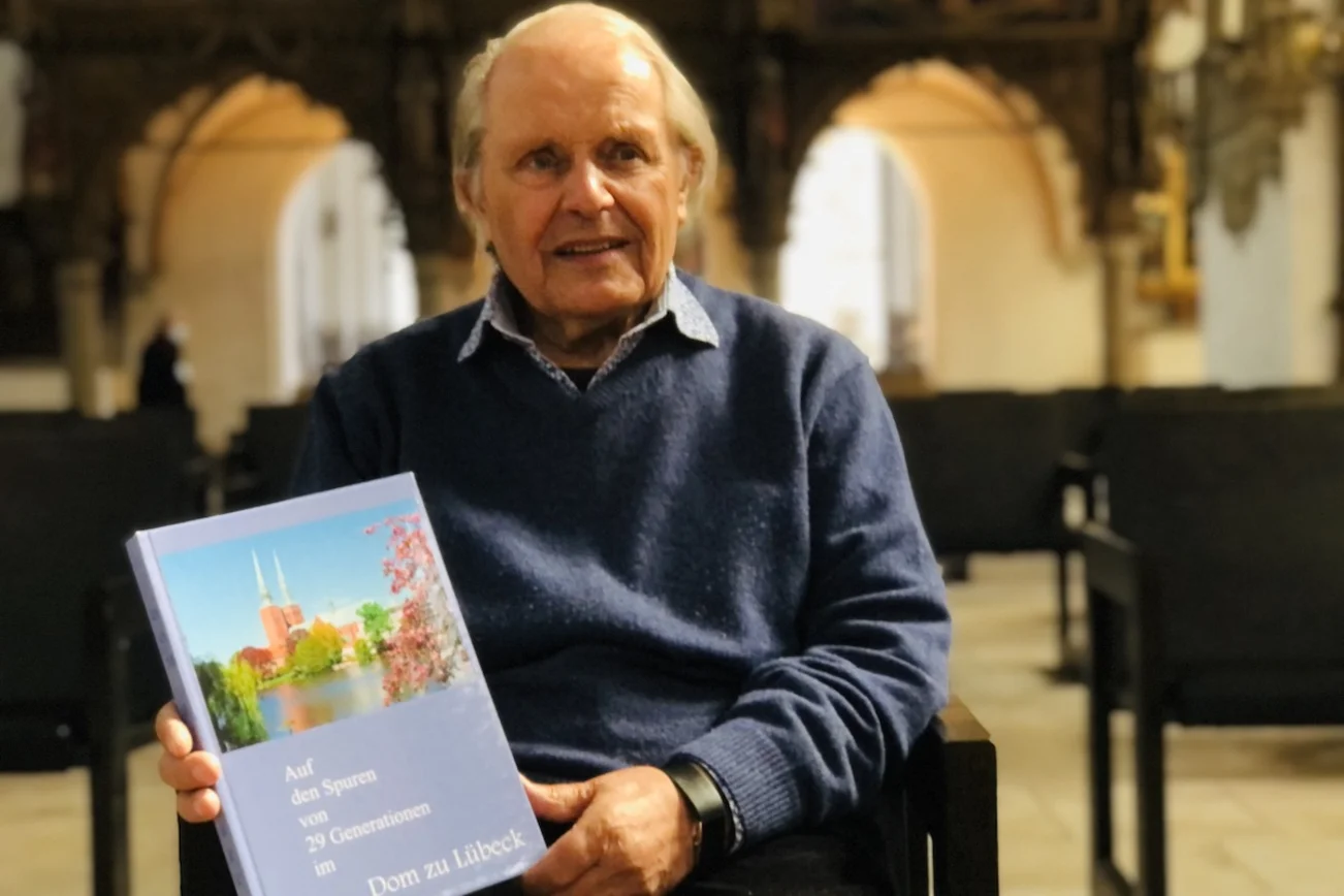 Gustav Querfurth mit seinem neuen Buch im Dom zu Lübeck.