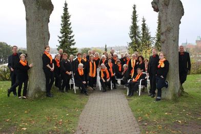 Viele Frauen und Männer in schwarzer Kleidung stehen zwischen zwei Bäumen - Copyright: Jasmin Schmidt