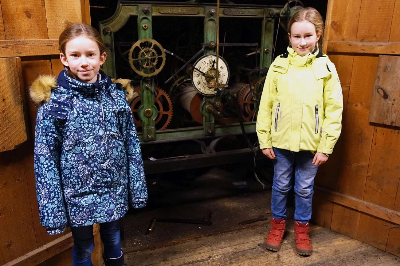 2 Mädchen vor einem alten Uhrwek