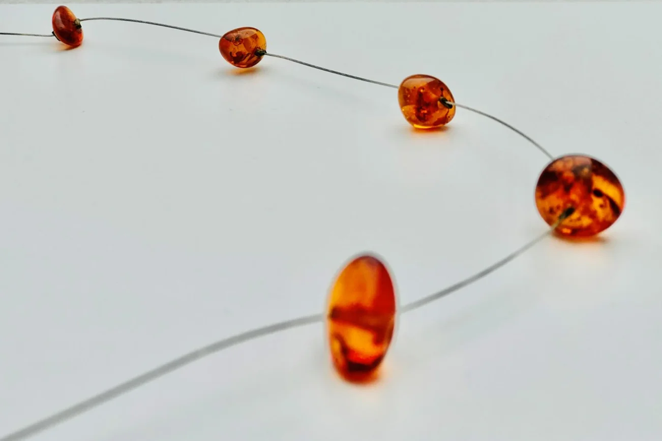 Kleine geschliffene Bernsteine an einer Kette aufgefädelt.