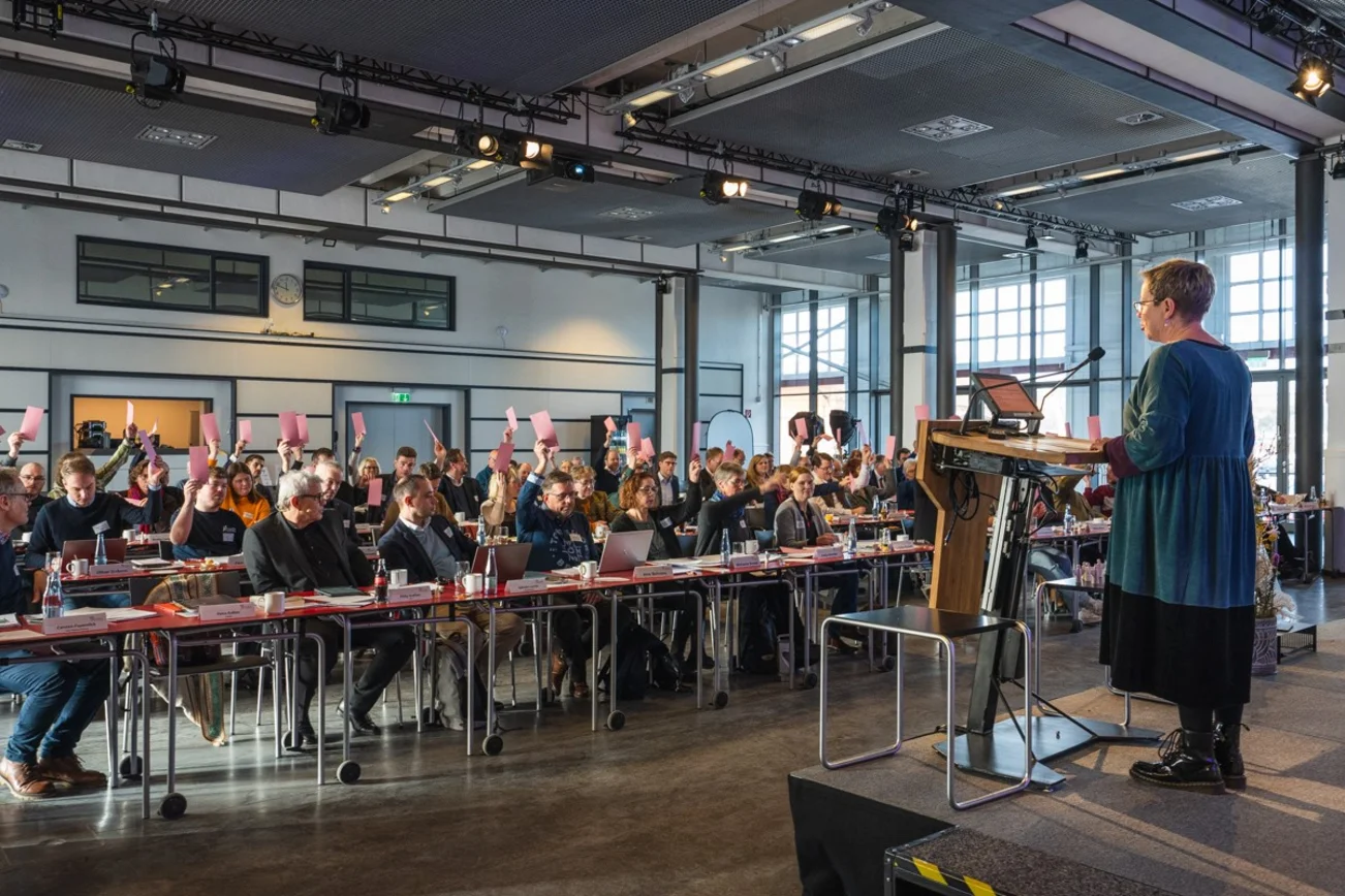 Auf der Synodentagung stimmen die Synodalen mit Karte über die Tagesordnung ab.