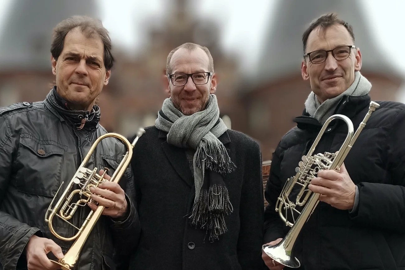 Drei Musiker vor dem Holstentor mit Instrumenten