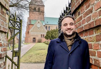 Ein Mann steht vor einer Kirche - Copyright: Oliver Pries