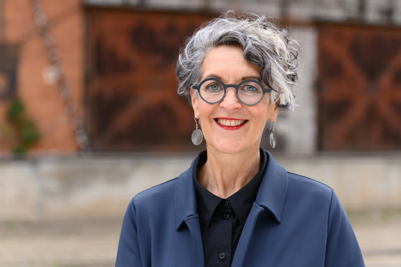 Eine Frau lächelt in die Kamera.