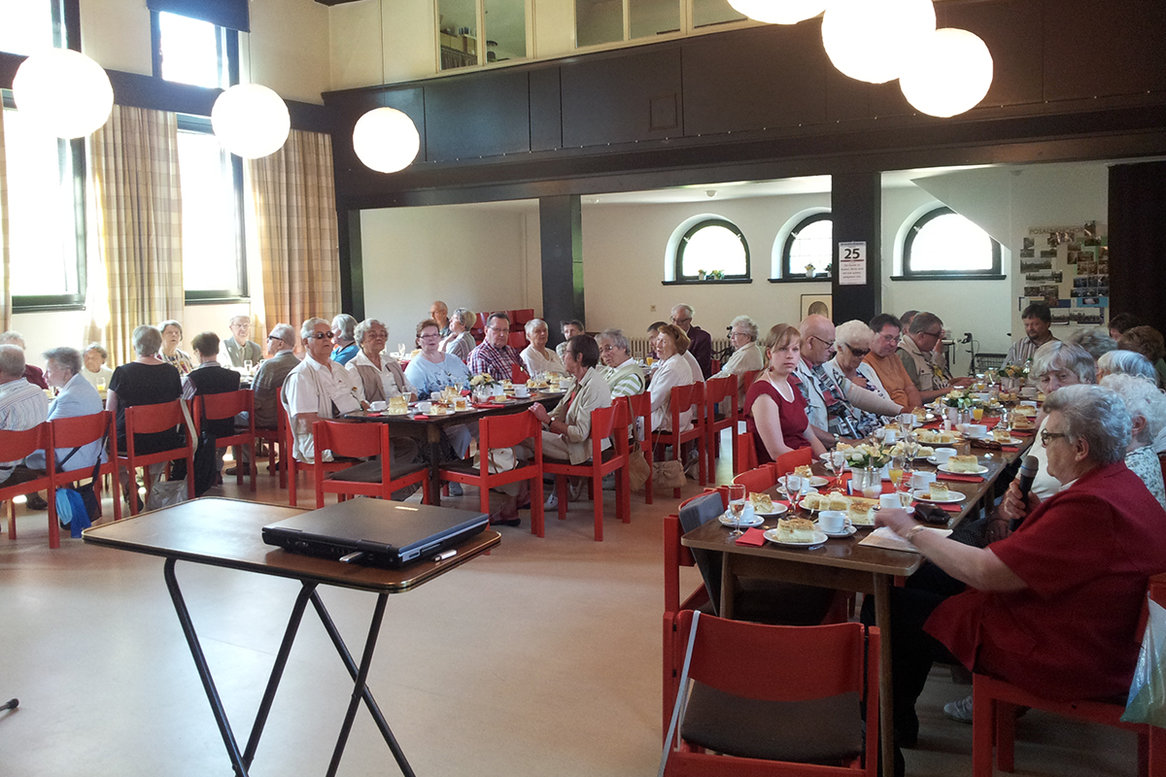 Viele Menschen sitzen an Tischen