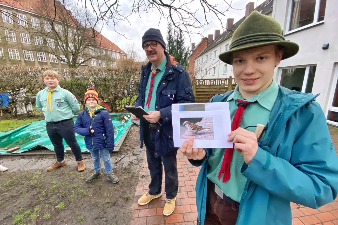 Vier Personen schauen während einer Veranstaltung in die Kamera. 