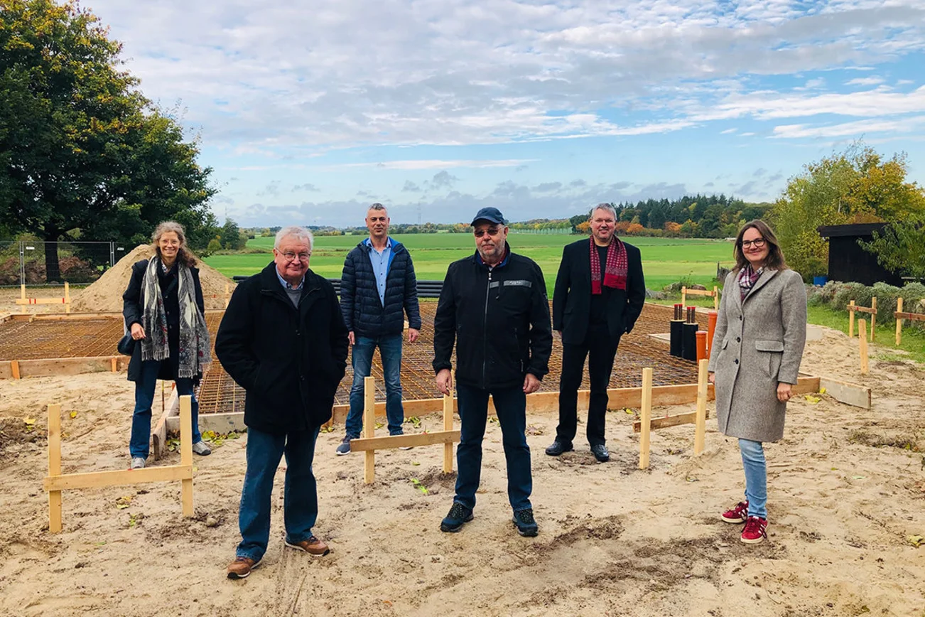 V. li.: Annette Piening, Umwelt- und Klimaschutzbüro der Nordkirche, Wolfgang Baaske, Ingenieurbüro Umweltschutz und Technik Harrislee, Ingenieur Andreas Tech, Bauabteilung des Kirchenkreises Lübeck-Lauenburg, Olaf Dey, Kirchengemeinderat Lütau, Michael Eggers, Bauausschussvorsitzender des Kirchgemeinderates und Pastorin Anna Christ vor der Plattform, an dem das Heizhaus in Kürze errichtet wird. Direkt dahinter wird die Solarthermie erbaut.