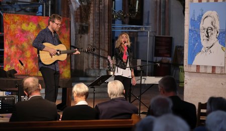 Ein Mann und eine Frau musizieren auf einer Bühne