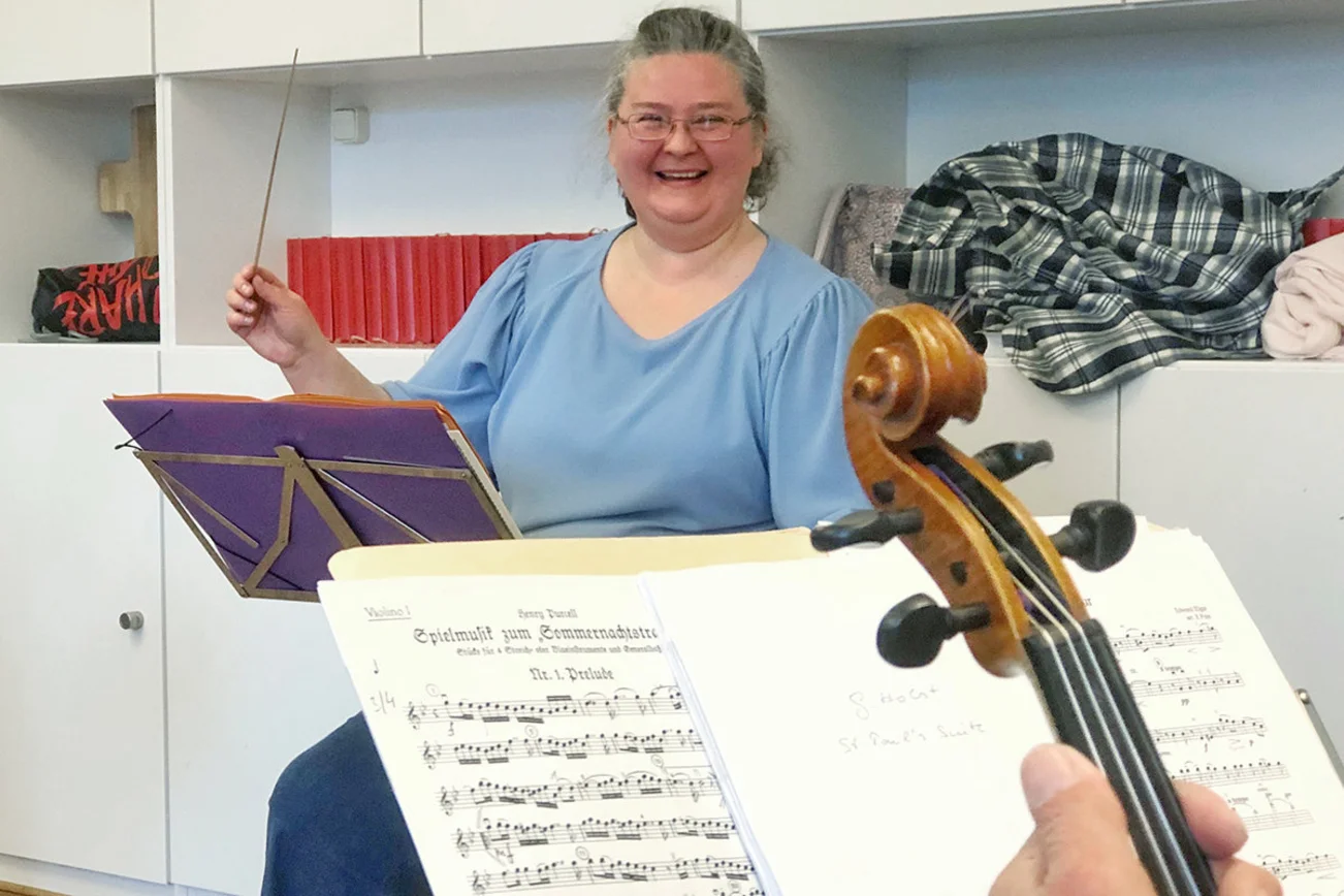 Olga Mull mit Taktstock vor dem Orchester