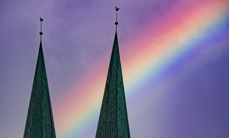 Zwei Kirchtürme mit einem Regenbogen