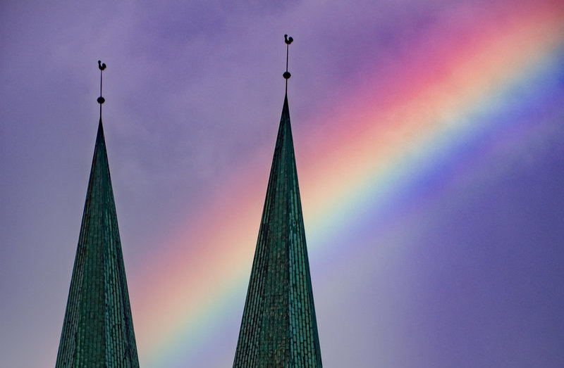 Zwei Kirchtürme mit einem Regenbogen