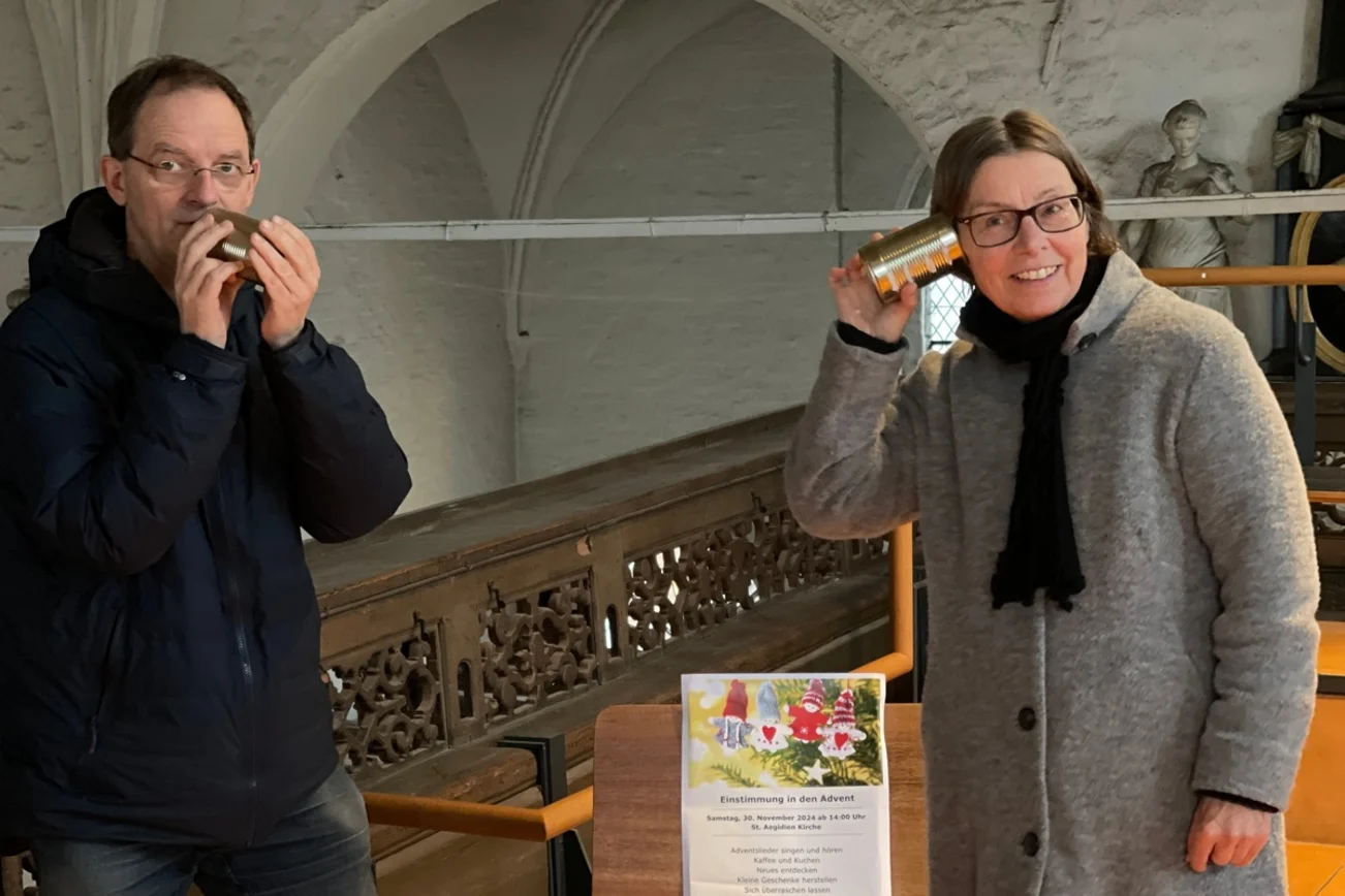 Ein Mann hält sich eine leere Dose an den Mund und eine Frau hält sich  an das Ohr.