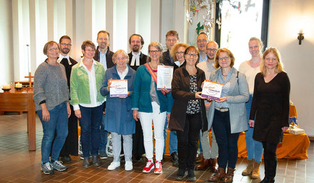 Gruppenbild von lächelnden menschen in einer Kirche.