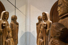 Eine Installation aus Holzfiguren vor einem Spiegel in der Lutherkirche