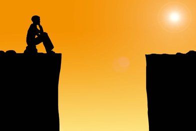 Eine Person sitz vor einer schwarzen Schlucht. Rechts im Bild scheint die Sonne durch einen orangefarbenen Hintergrund. - Copyright: Gemeindebrief.de -  Grafik: Pfeffer