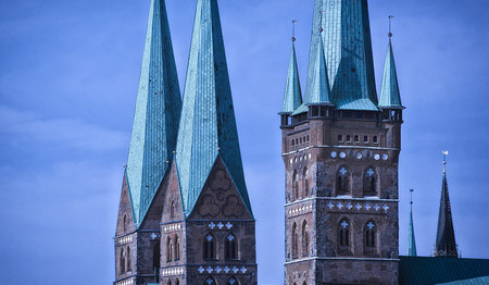 Die Kirchtürme St. Petri und St. Marien ragen in den Abendhimmel