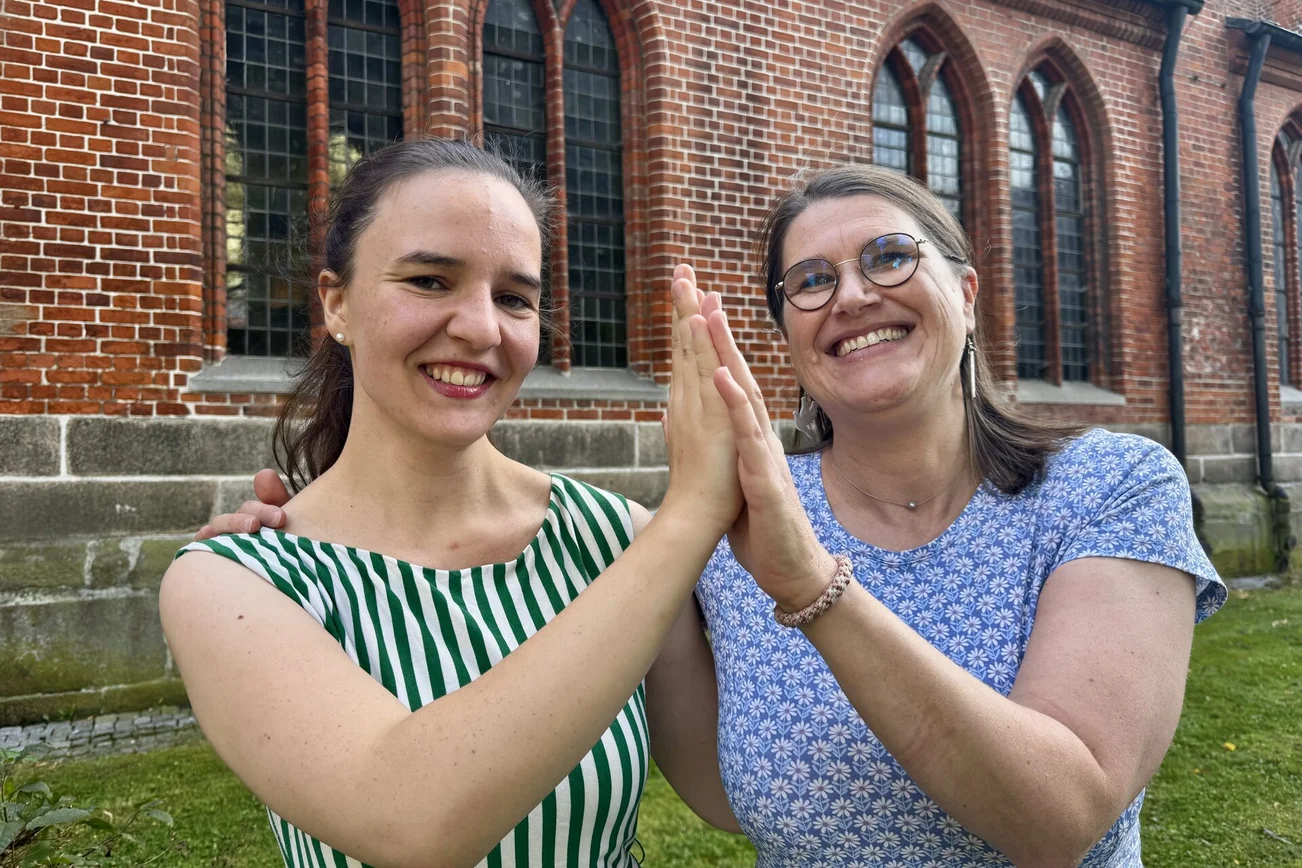 Zwei Frauen vor einer Kirche